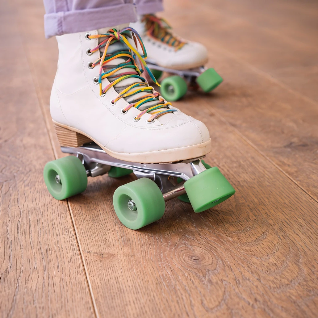 Eine Nahaufnahme von Rollschuhen auf einem mit Kiwi-Now-Bodenpaneelen des Modells 91KN742 ausgelegten Boden.